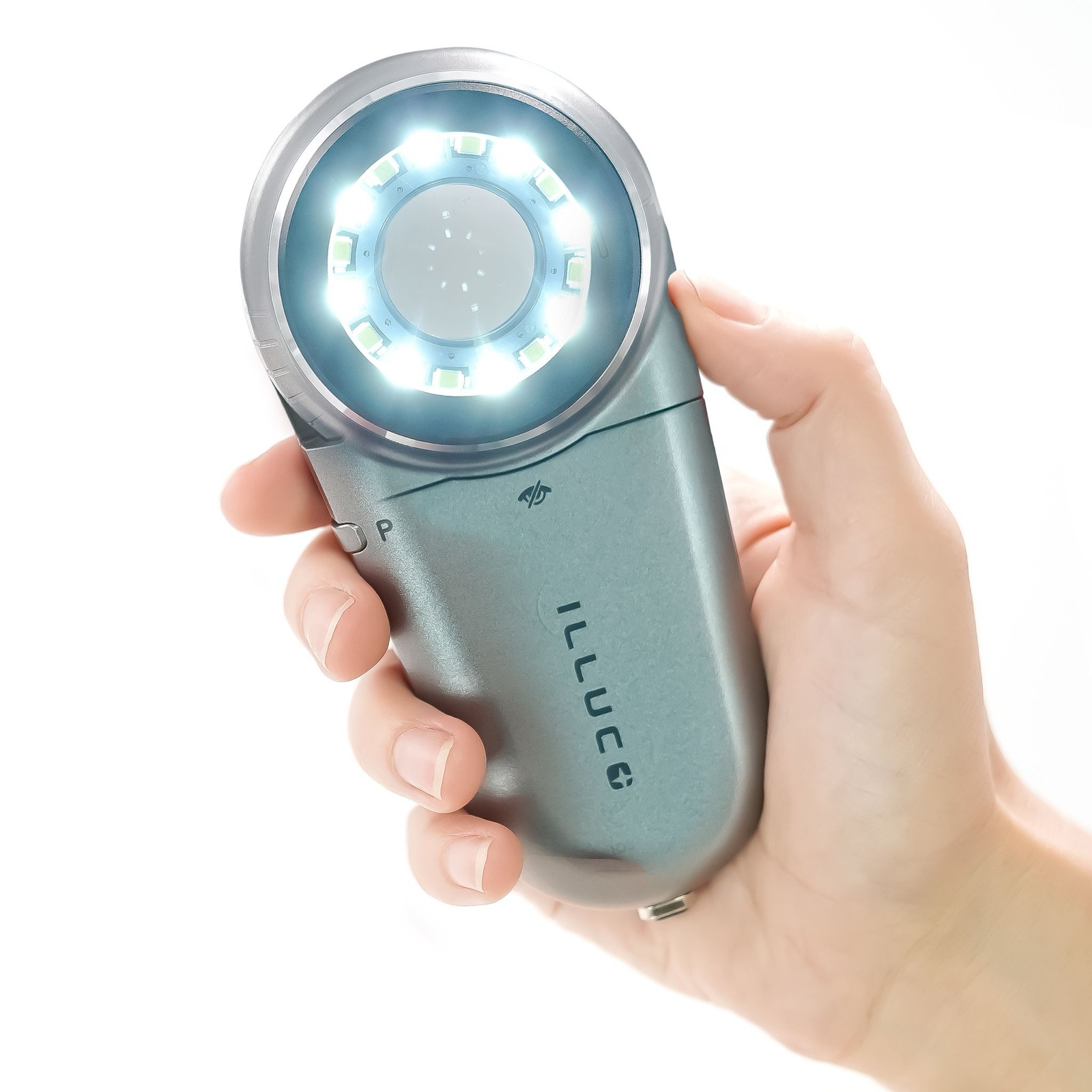 Handheld dermatoscope held in a hand with its light switched on